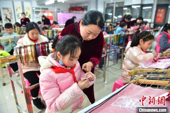 江西省級(jí)非遺豫章繡傳承人手把手指導(dǎo)小學(xué)生繡制2022年北京冬奧會(huì)吉祥物“冰墩墩”形象?！∮髟屏?攝