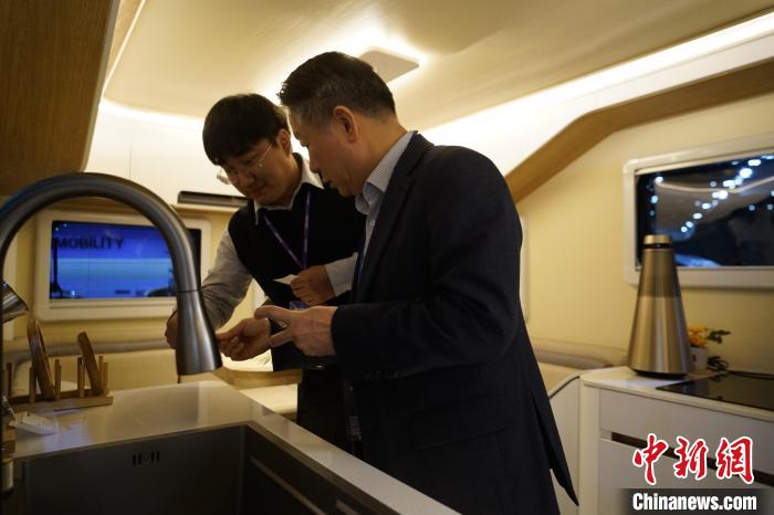 圖為參展商向觀眾介紹房車內(nèi)部設計?！⑿?攝