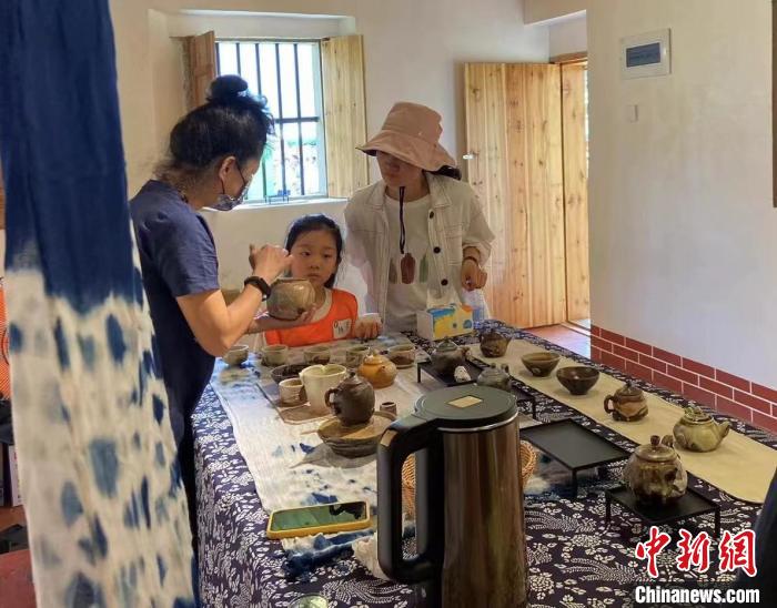 圖為：游客正在咨詢(xún)臺(tái)灣柴燒作品?！∪~秋云 攝