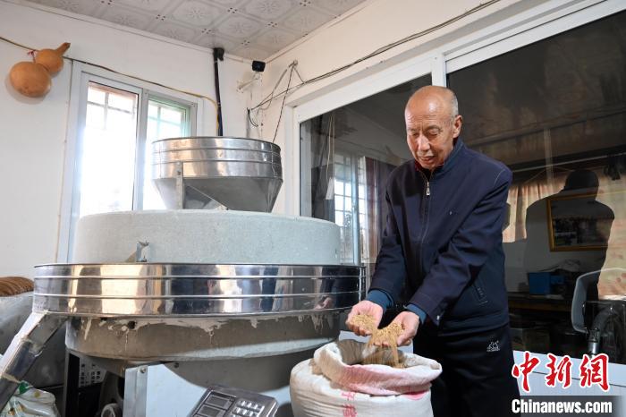 李家莊村民谷文朝重拾父輩的手藝，做起石磨面粉的營生?！〉杂鸺?攝