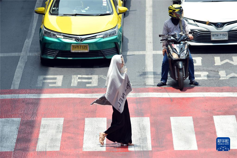5月17日，行人在泰國曼谷街頭用圍巾遮陽。新華社發(fā)（拉亨攝）