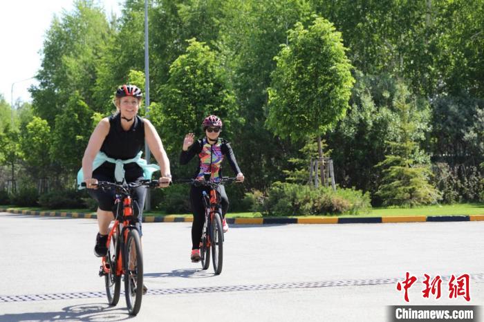 亞信副秘書長遲方(右一)與聯(lián)合國駐哈協(xié)調(diào)員在騎行活動中。　亞信秘書處供圖