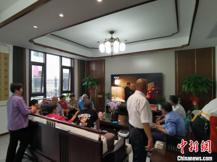 親友們集中在費(fèi)俊龍家中觀看返程的視頻。　鐘升 攝