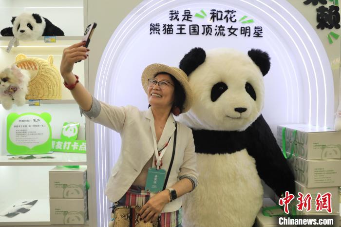 美國華視總裁楊蓮花與大熊貓文創(chuàng)產(chǎn)品合影?！⊥趵?攝