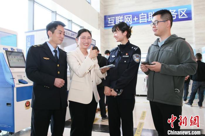 4月10日，安徽合肥，一家運輸企業(yè)負責人在工作人員的指導下，使用小程序辦理車管業(yè)務?！『戏示焦﹫D