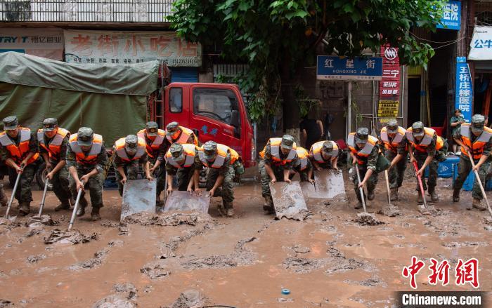 7月4日，萬州區(qū)五橋街道，武警官兵清理街道上的淤泥。　冉孟軍 攝