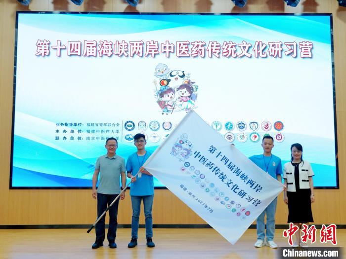 共青團(tuán)福建省委副書記吳雪(右一)、福建中醫(yī)藥大學(xué)黨委副書記林羽(左一)為兩岸學(xué)生代表頒授營旗。　許燁婷 攝