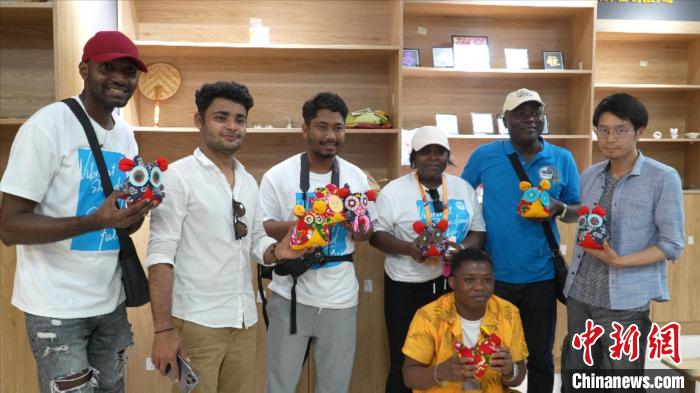 圖為國際青年代表展示親手制作的東營非遺黃河口布偶 ?！↓R魯 攝