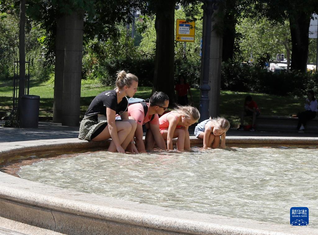 7月8日，人們在德國法蘭克福的一處噴泉玩水。近日，德國法蘭克福逐漸迎來暑熱天氣。新華社記者 張帆 攝