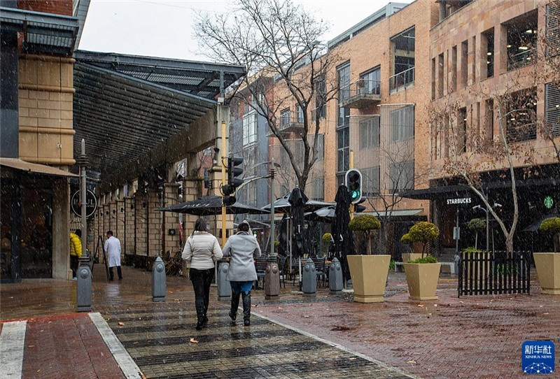 7月10日，在南非約翰內(nèi)斯堡一處商業(yè)區(qū)，人們?cè)谘┲行凶摺Ｐ氯A社記者 張譽(yù)東 攝