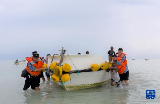 7月21日，中國海軍“和平方舟”號(hào)醫(yī)院船醫(yī)護(hù)人員涉水登島，前往基里巴斯一診療點(diǎn)。新華社記者 黎云 攝