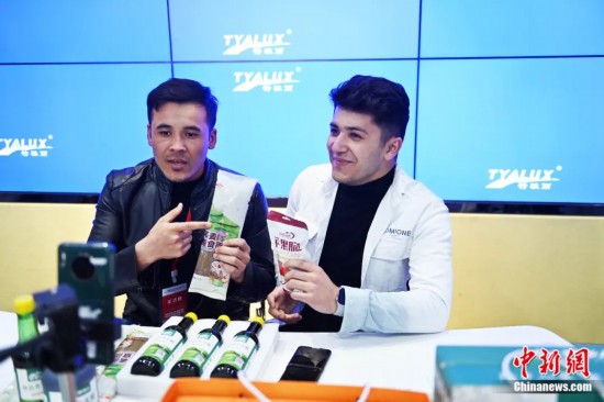 2023年3月，甘肅省慶陽市環(huán)縣電商創(chuàng)業(yè)孵化基地內(nèi)，來自蘭州文理學(xué)院的塔吉克斯坦留學(xué)生正在協(xié)助主播直播帶貨當(dāng)?shù)剞r(nóng)特產(chǎn)品。李亞龍 攝