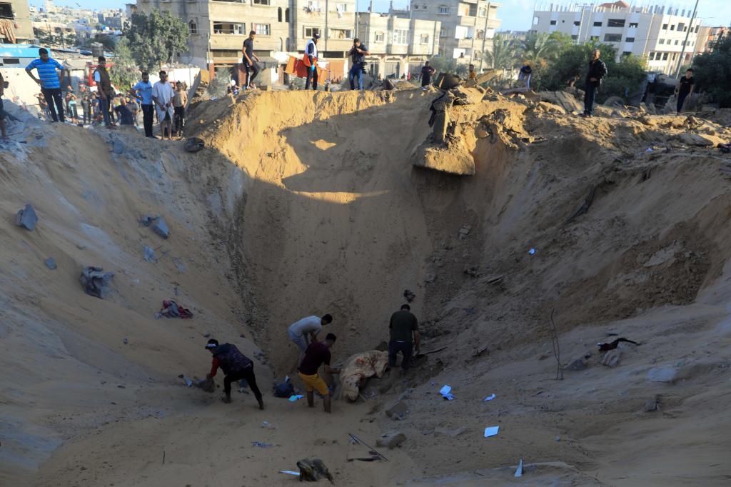 10月16日，在加沙地帶南部城市汗尤尼斯，人們?cè)谠庖陨幸u擊后的建筑廢墟中救援傷者。 新華社發(fā)（亞西爾·庫(kù)迪 攝）