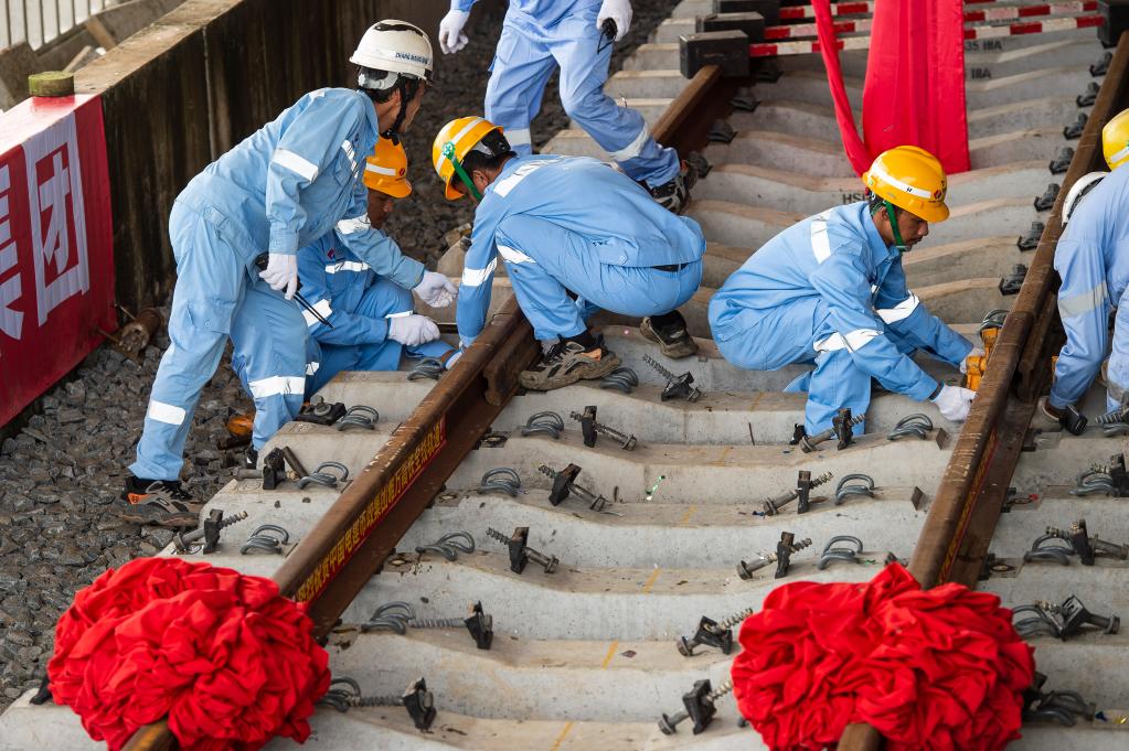 3月31日，在印度尼西亞雅加達雅萬高鐵哈利姆車站，工人鋪設(shè)雅萬高鐵全線最后一根鋼軌。