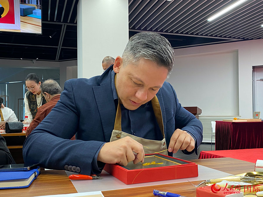 2023“一帶一路”媒體合作論壇聯(lián)合采訪團(tuán)團(tuán)員，親身體驗(yàn)景泰藍(lán)工藝。人民網(wǎng)記者 于洋攝