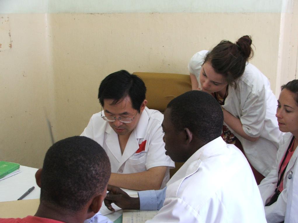 2011年7月22日，在坦桑尼亞桑給巴爾納茲莫加醫(yī)院外科門診，中國第24批援桑給巴爾醫(yī)療隊隊長盧建林為當?shù)鼗颊咴\治并帶教實習生。新華社發(fā)（國家衛(wèi)生健康委供圖）