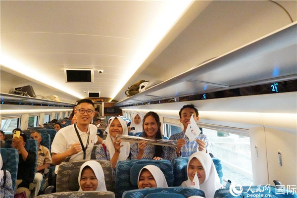 第一次乘坐雅萬高鐵動車組的學生們與動車組模型合影。人民網(wǎng)記者曹師韻攝