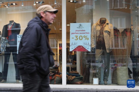   10月31日，一名男子從比利時(shí)布魯塞爾一家貼有打折信息的店鋪前走過(guò)。新華社記者 趙丁喆 攝