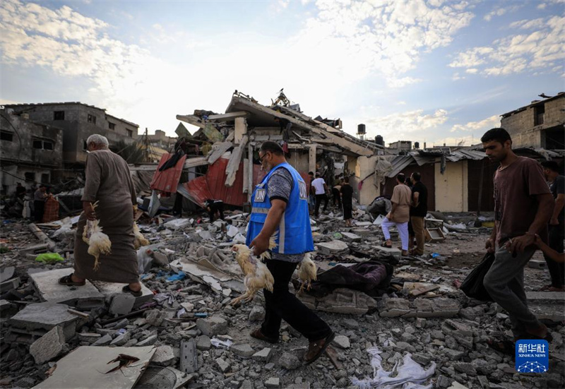 10月27日，在加沙地帶南部城市汗尤尼斯，人們經過以軍襲擊后的房屋廢墟。