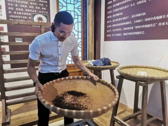 2023“一帶一路”媒體合作論壇聯(lián)合采訪團團員在非遺文化展示館體驗中藥炮制技藝。（本報記者 黃超攝）