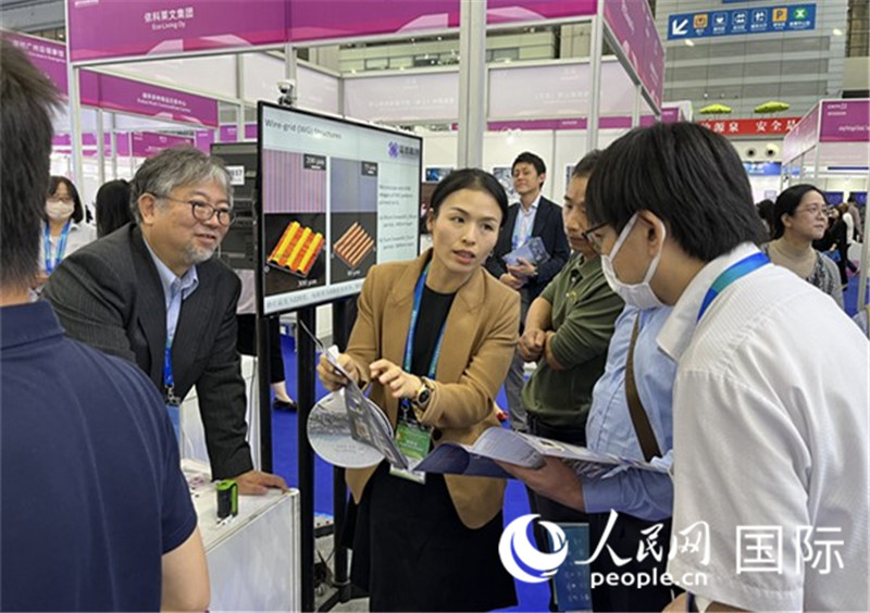 工作人員向參觀者介紹超級(jí)噴墨技術(shù)。（人民網(wǎng)記者 陳思攝）