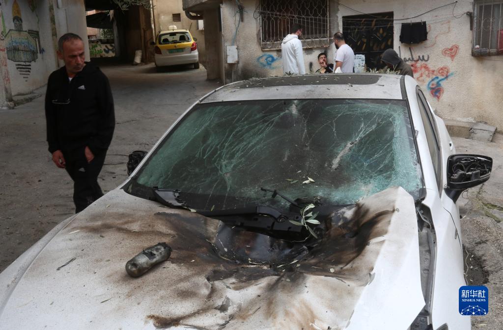 12月17日，在約旦河西岸城市圖勒凱爾姆附近的一處難民營，人們查看在沖突中損毀的車輛。新華社發(fā)（尼達爾·艾仕塔耶?dāng)z）