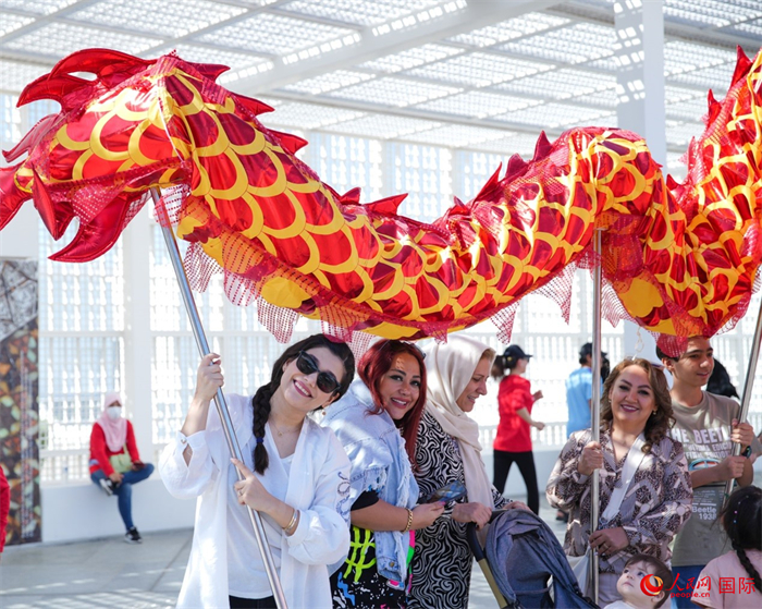 游客體驗舞龍。 人民網(wǎng) 塔里克·易卜拉欣攝