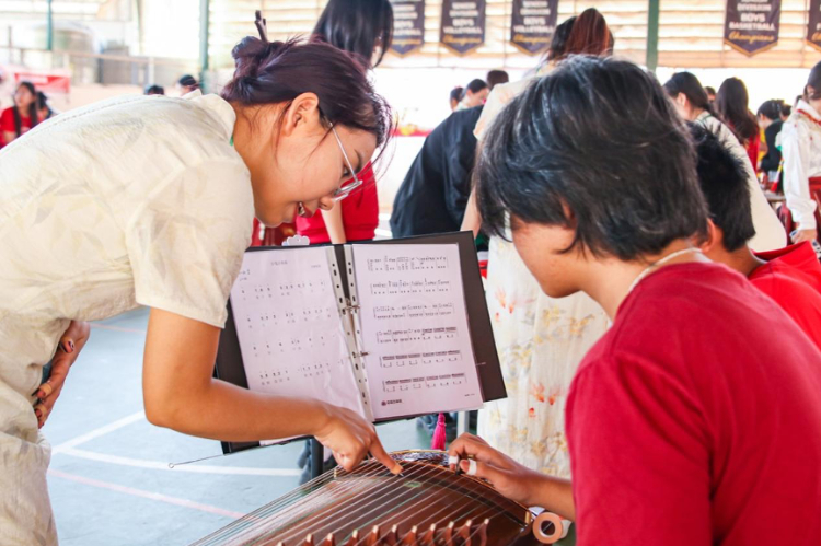 志愿者教師指導(dǎo)學(xué)生彈奏古箏?；顒?dòng)主辦方供圖