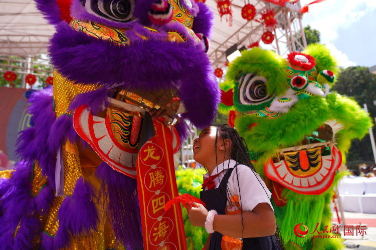 小朋友與舞獅表演者互動(dòng)。人民網(wǎng)記者 黃煒鑫攝