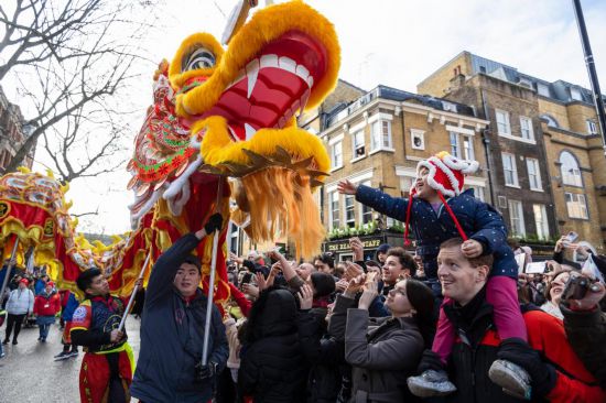 2月11日，人們?cè)谟?guó)倫敦的新春巡游活動(dòng)中觀看舞龍表演。新華社發(fā)（史蒂芬·程攝）