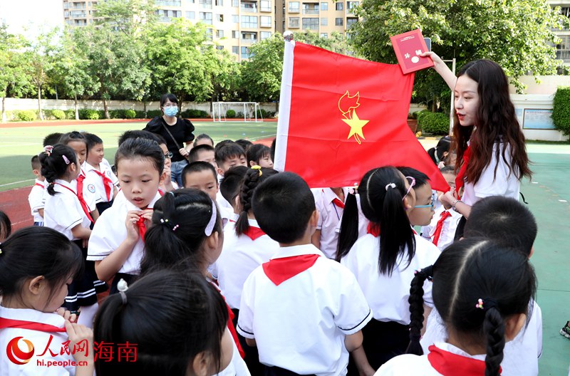 老師向少先隊(duì)員展示隊(duì)旗。人民網(wǎng) 符武平攝
