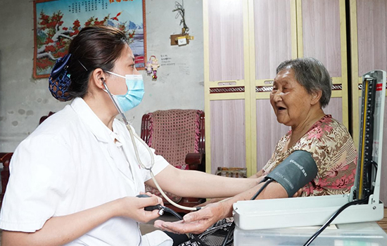 護(hù)理團(tuán)隊(duì)醫(yī)生為老人測(cè)量血壓。 陳佳兵攝