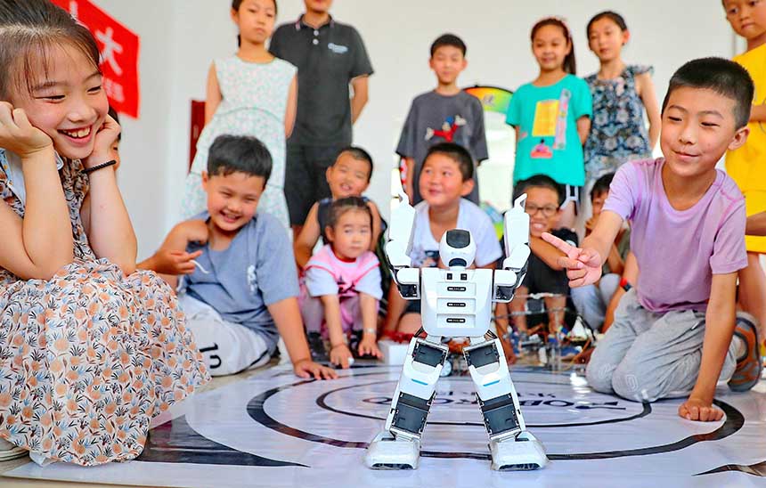 2022年7月19日，河北省秦皇島市海港區(qū)白塔嶺街道秦皇半島第二社區(qū)內(nèi)，小朋友正在觀看“機(jī)器人跳舞”。 曹建雄攝