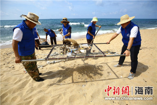 環(huán)保志愿者用篩網(wǎng)“淘”出海灘上的垃圾。