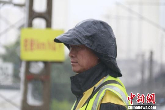 蘭州西工務(wù)段蘭州線路車間防護(hù)員雨中巡查?！⊥豕廨x 攝