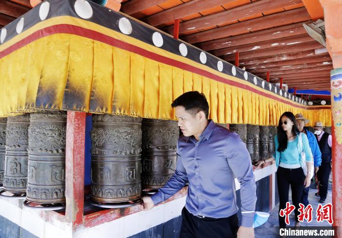 圖為外籍嘉賓體驗(yàn)藏族傳統(tǒng)轉(zhuǎn)經(jīng)筒?！●R銘言 攝