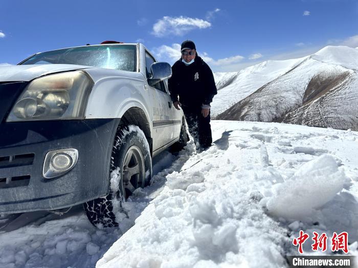 圖為生態(tài)管護人員準備在雪地推車?！《“瓦_杰 攝