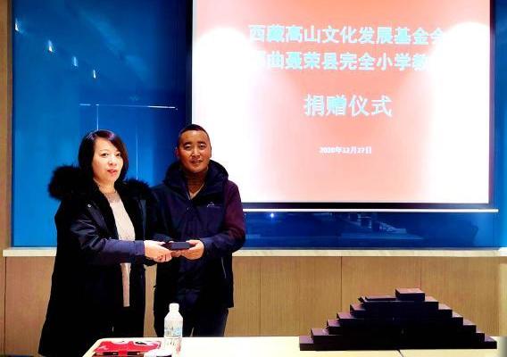圖為西藏高山文化發(fā)展基金會(huì)理事長(zhǎng)溫麗向聶榮縣完全小學(xué)負(fù)責(zé)人捐助儀器?！∮谫e 攝