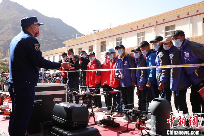 圖為消防指戰(zhàn)員為學(xué)生講解、演示先進(jìn)救援裝備?！≮w琳 攝