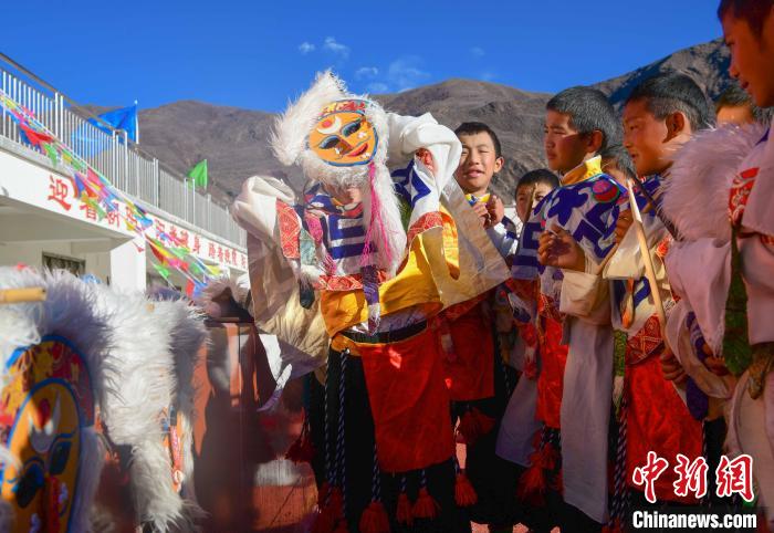 圖為加查縣安繞鎮(zhèn)小學學生在試穿藏戲面具?！∝暩聛硭?攝