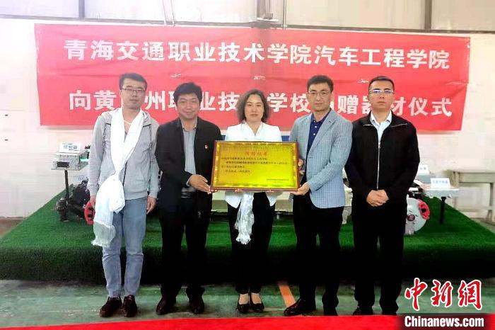 圖為李富香(中)代表學(xué)校為州縣技校捐贈(zèng)器材。(資料圖) 青海省教育廳供圖