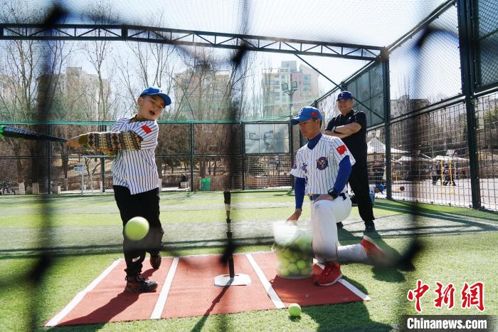 圖為教練指導(dǎo)小棒球手進行擊球訓(xùn)練?！●R銘言 攝