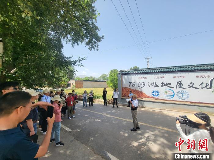 圖為中國地質(zhì)大學(xué)(北京)教授張緒教介紹村落情況。　胡友軍 攝