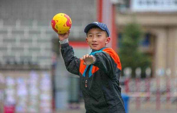 在高原上教孩子們打手球，“慢慢兒來(lái)，甭著急！”