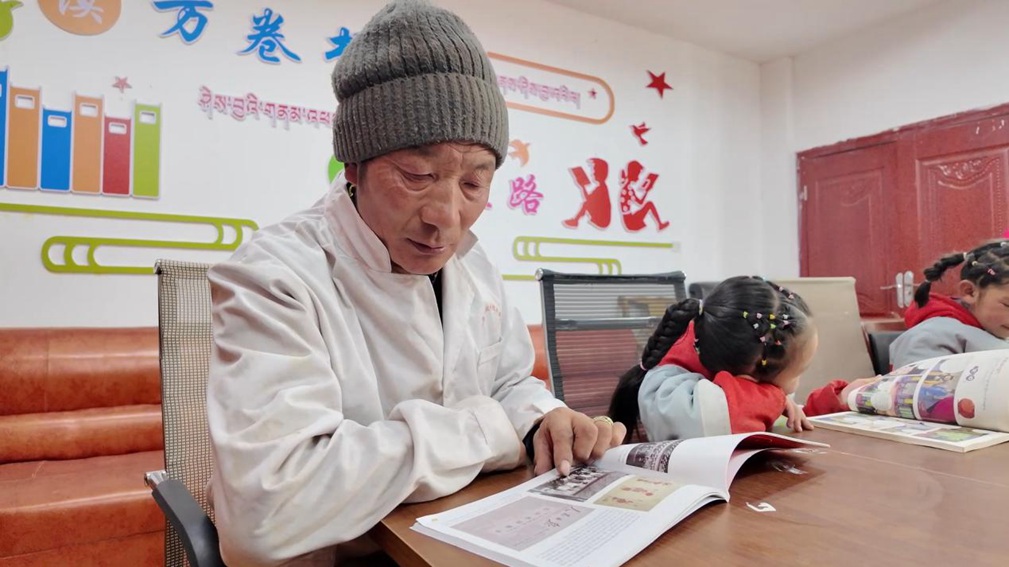 一位當?shù)卮迕窈秃⒆觽冊谀良視堇锉M情享受閱讀時光。申扎縣融媒體中心供圖