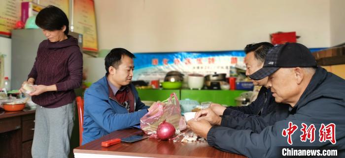 圖為扶貧路上“臨時(shí)一家人”準(zhǔn)備午餐?!∥航ㄜ?攝