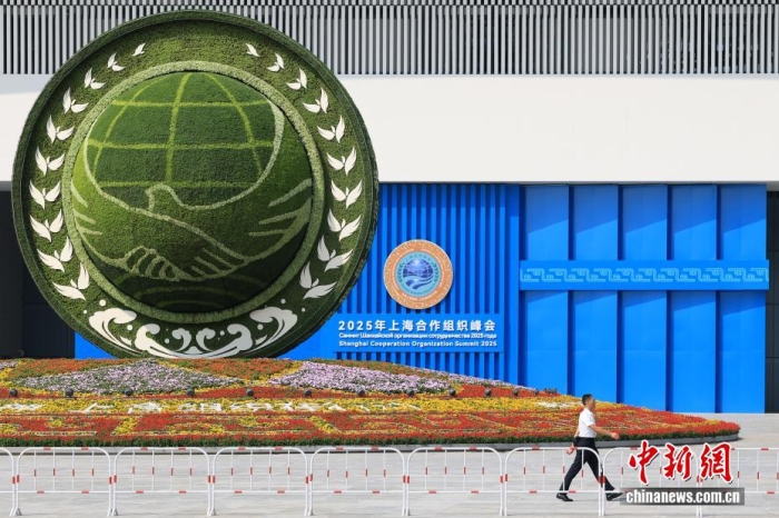 8月31日，天津，一名工作人員從2025年上海合作組織峰會主會場外的景觀花壇旁經(jīng)過。當日，2025年上海合作組織峰會在天津舉行。<a target='_blank' href='/'><p  align=