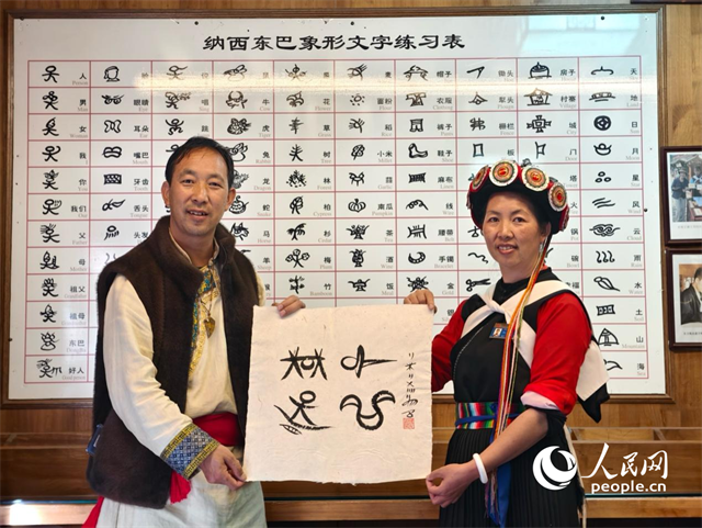 人民網(wǎng)“行進中國”云南調(diào)研采訪團走進麗江，和閏元現(xiàn)場用東巴文寫下“行進中國”。人民網(wǎng)記者 符皓攝