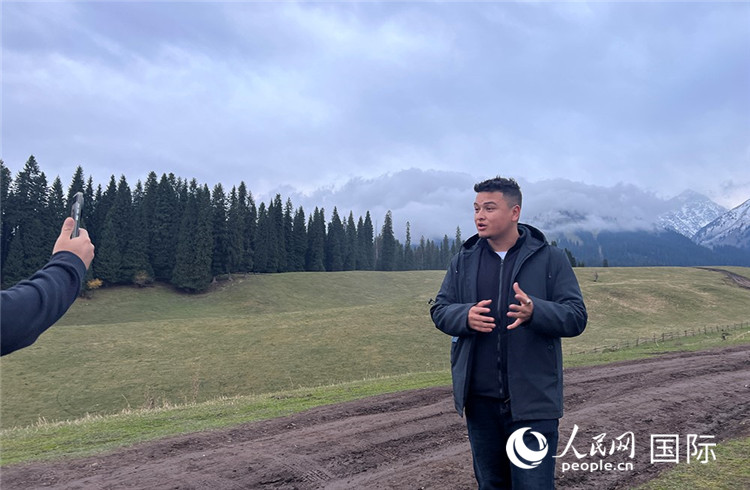 在庫爾德寧，吾買爾江被雪山美景震撼，即興錄制了短視頻作品。人民網(wǎng)記者曾書柔攝