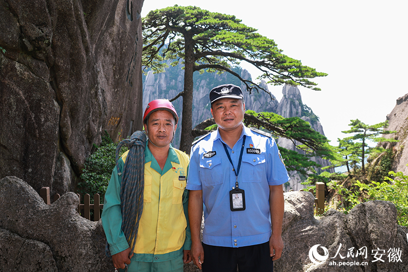 全國(guó)道德模范李培生（左）和胡曉春在迎客松前合影。人民網(wǎng)記者 張俊攝